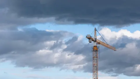 Ein Baukran unter dunklen Wolken